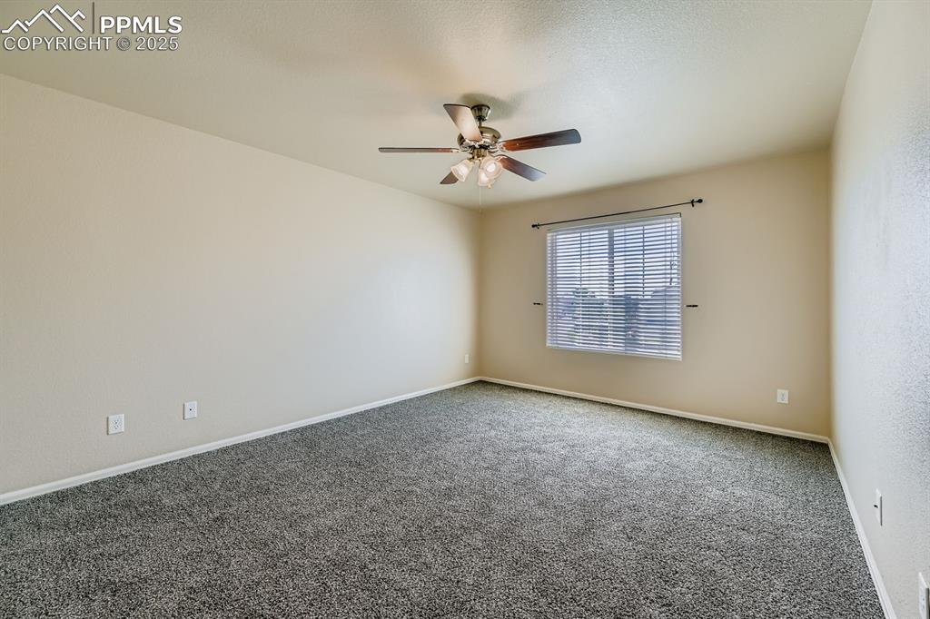 Empty room featuring carpet flooring and ceiling fan