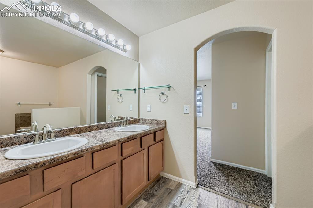 Bathroom with double vanity and dark wood finished floors