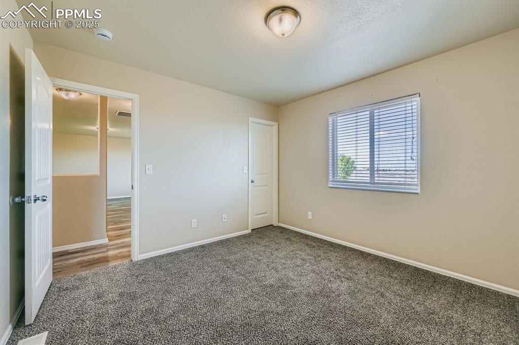 Unfurnished bedroom with baseboards and carpet flooring