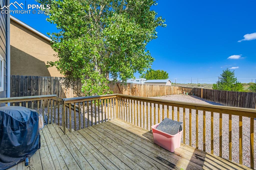 Wooden deck featuring grilling area and a fenced backyard