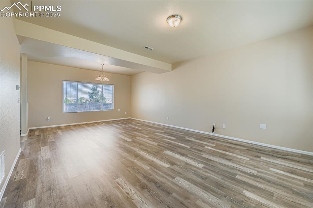 Unfurnished room with light wood-style flooring and a chandelier