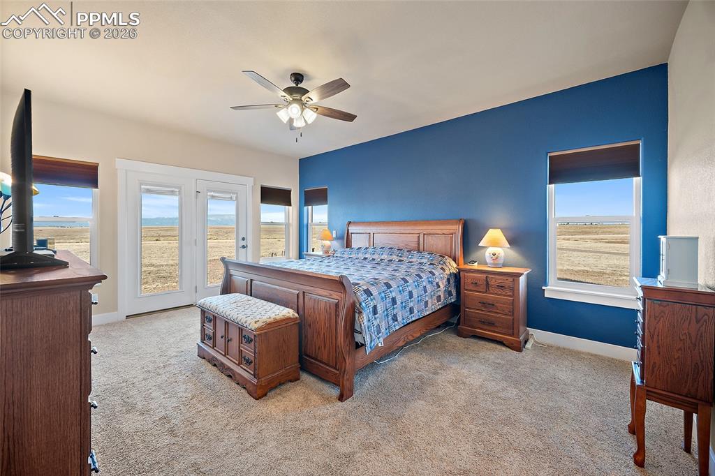 Primary bedroom with walkout to covered patio and mountain views.