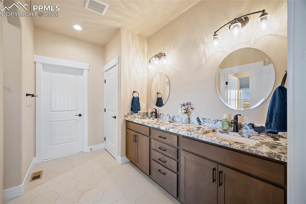 Quartz countertops and dual vanities.