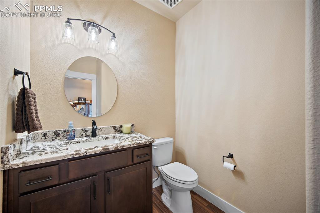 Main level 1/2 bathroom with quartz countertops.