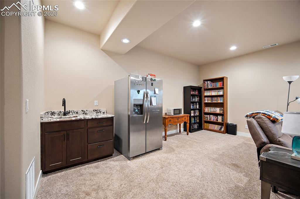 Lower level family room with wet bar, quartz countertops and full size refrigerator.