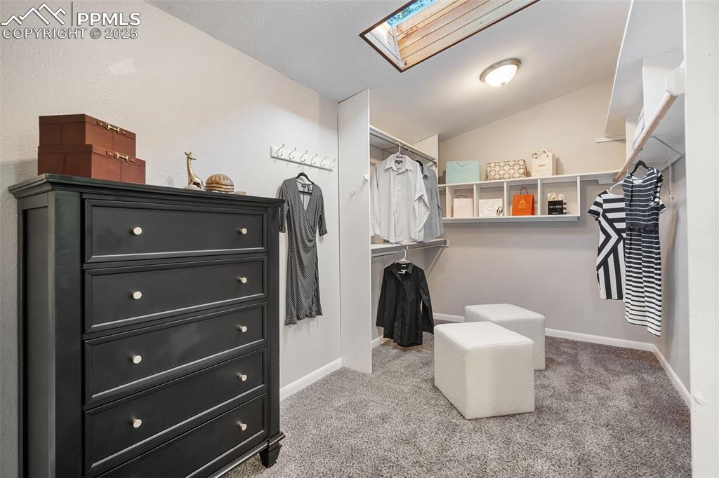Primary walk-in closet/dressing room with cedar skylight