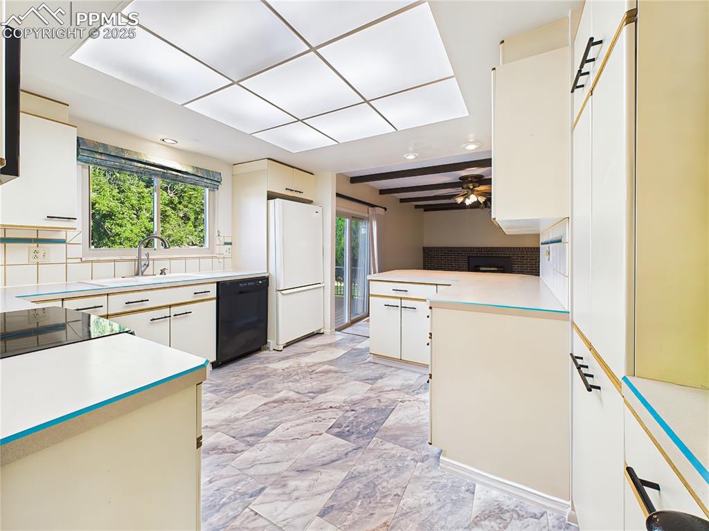 Kitchen & Family Room Overview – Spacious eat-in kitchen with newer luxury flooring, ample cabinet storage, and open sightlines to the family room and backyard access.