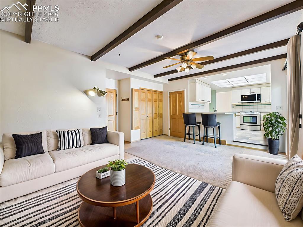 Virtually Staged Family Room brings to life the cozy family room with beamed ceilings, gas fireplace with brick surround, and open access to the kitchen and deck—perfect for everyday living.