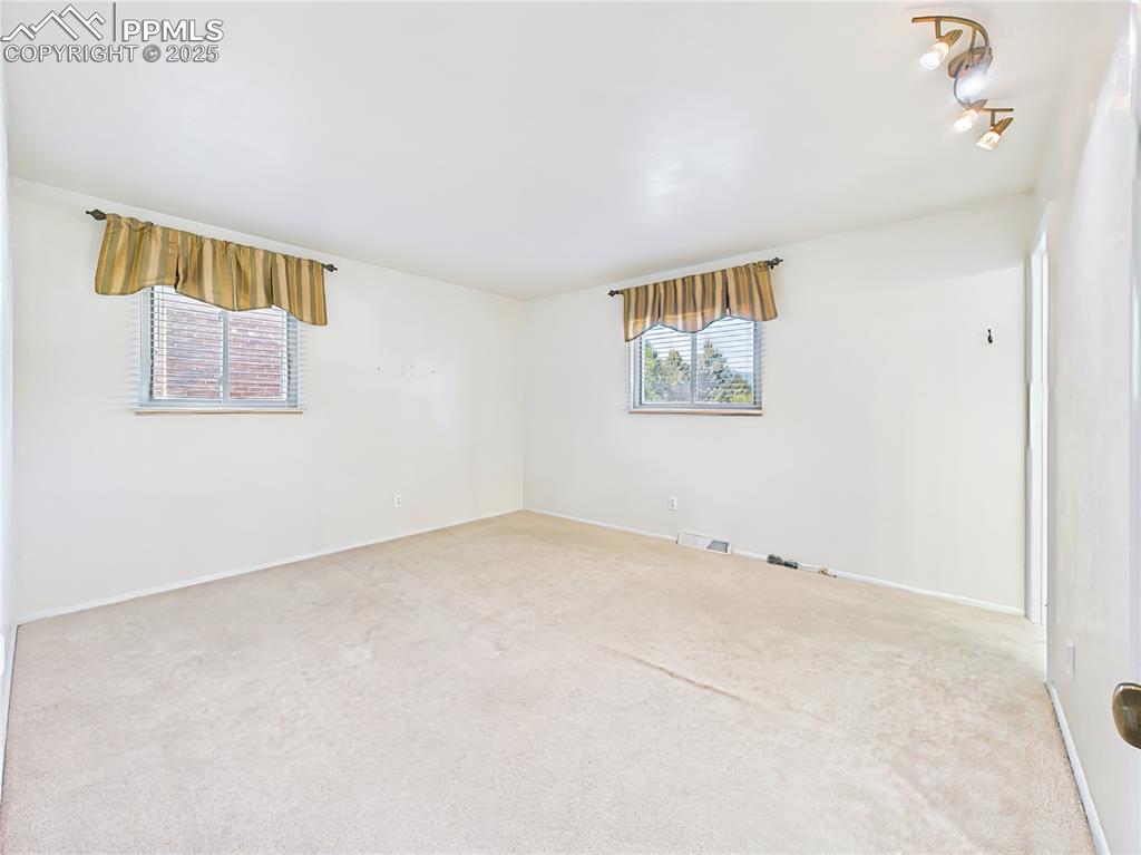 Primary Bedroom (Unfurnished) – Large and bright, this primary bedroom features neutral tones and dual windows for natural light, along with easy access to a walk-in closet.