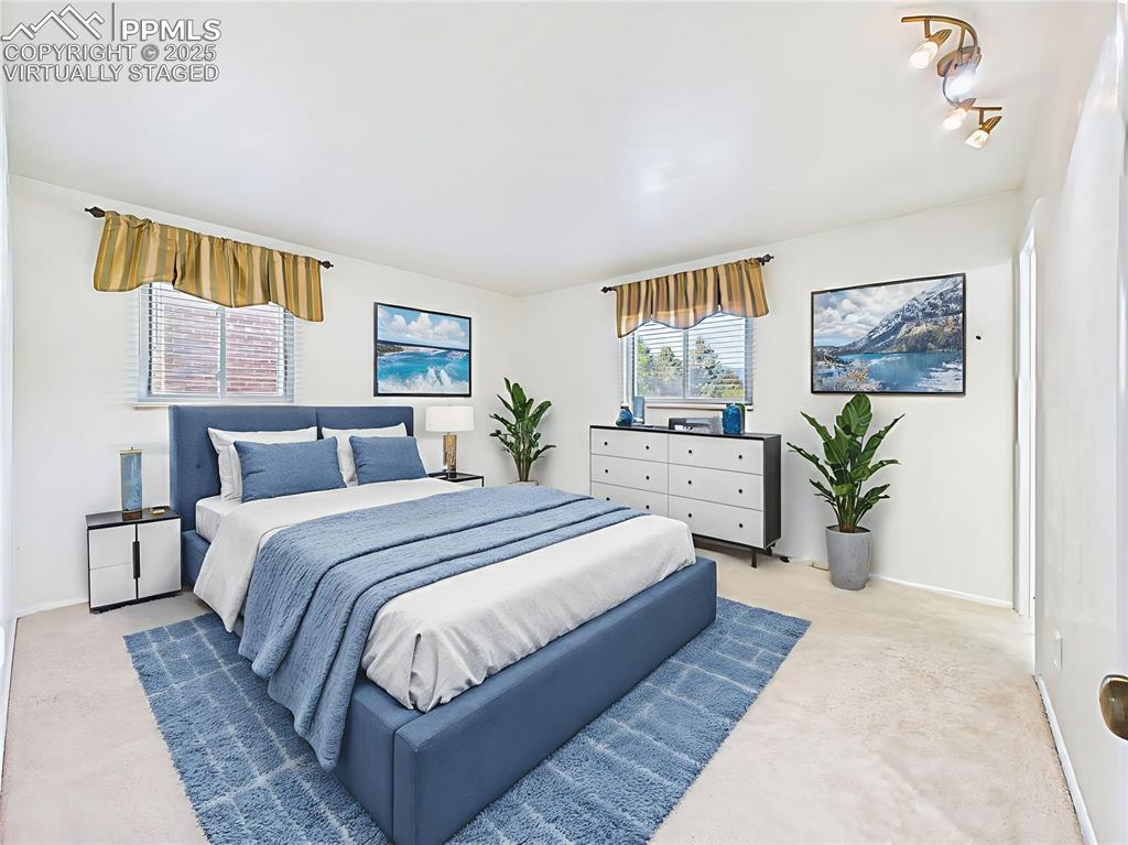 Virtually Staged Primary Bedroom  highlight its layout, offering dual windows, soft carpet, and plenty of space for a king-sized bed and furnishings.