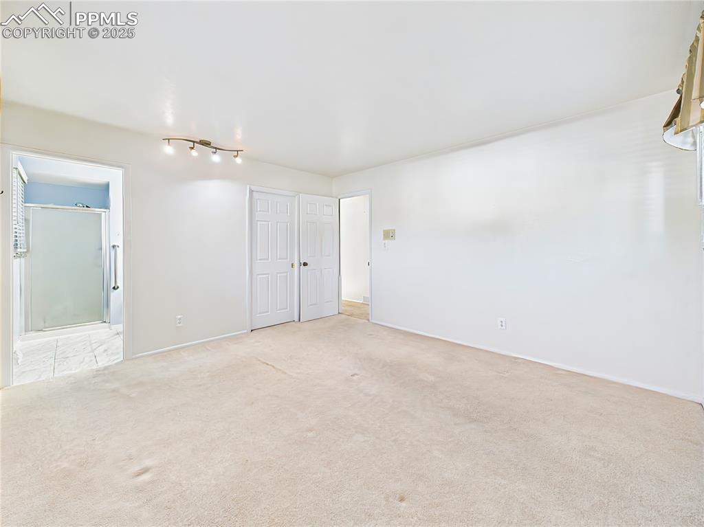 Primary Bedroom with En-Suite (Unfurnished) – A spacious primary retreat with carpet flooring, large layout, and private en-suite bath—complete with mountain views from the window.