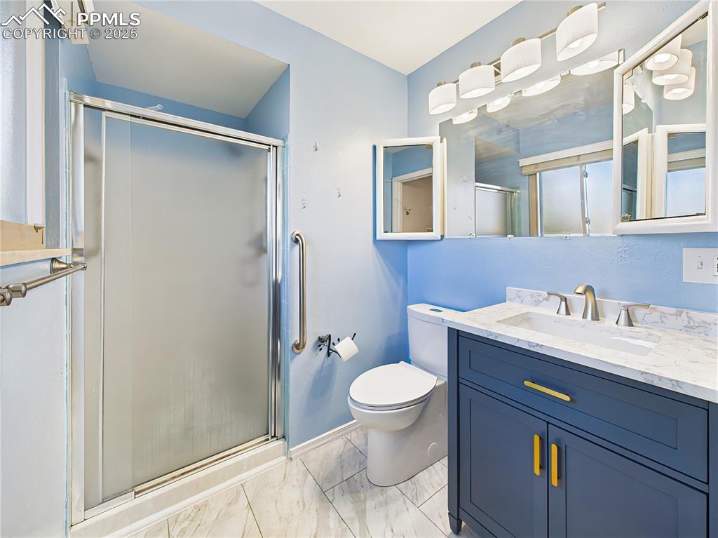 Primary Bathroom – Recently updated with a modern navy vanity, marble-look countertop, new fixtures, and tiled floors, this en-suite bathroom is both stylish and functional.