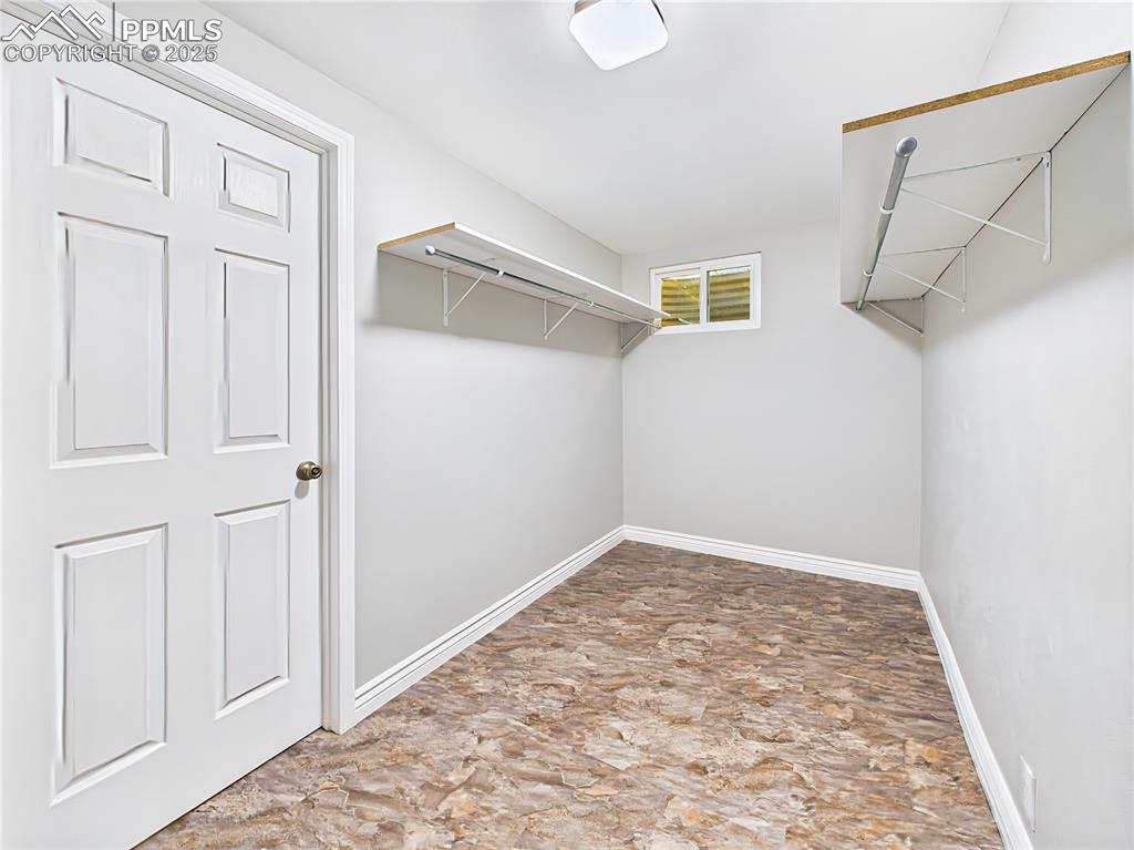 Walk-In Closet (Basement Level) – oversized walk-in closets in the home, this lower-level closet offers exceptional storage with shelving and rods on both sides and upgraded luxury flooring (2023).