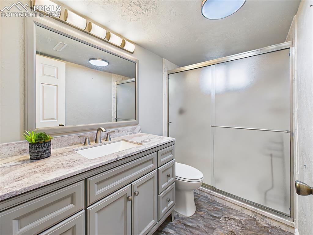 Downstairs Bathroom (2023 Renovation) – Fully renovated in 2023, this modern basement bathroom features a sleek vanity, granite-look countertop, upgraded fixtures, new luxury flooring, and a large glass-enclosed shower.