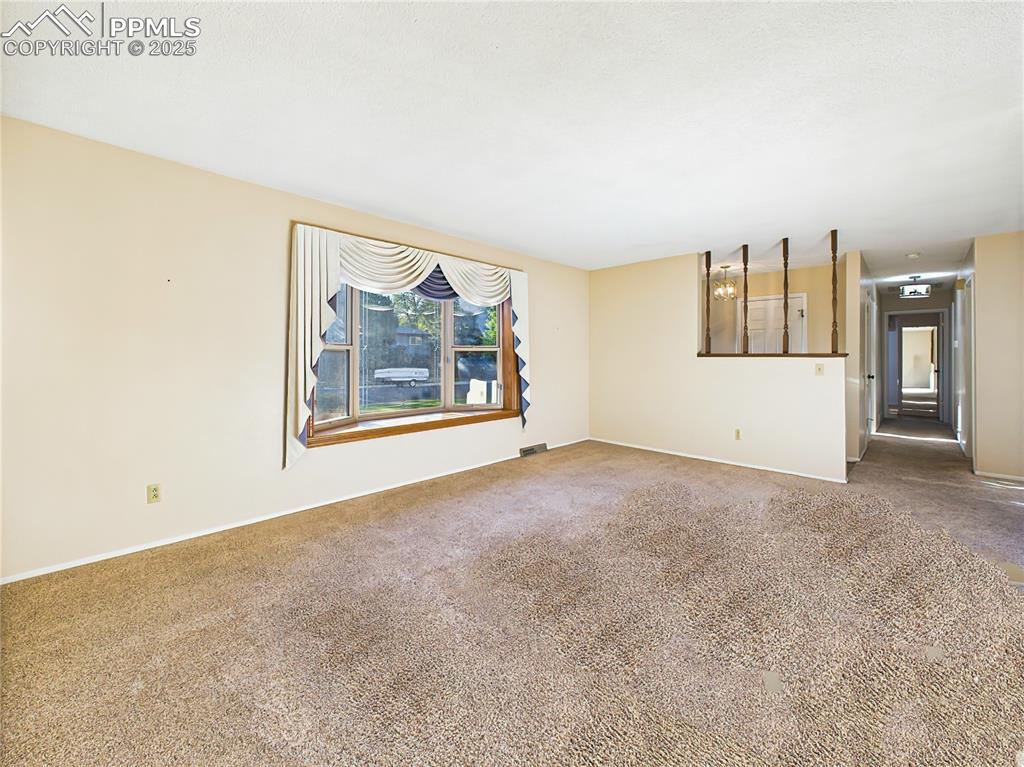 Alternate View of Living Room (Empty) – Another view of the living room reveals its seamless flow to the foyer and hallway, along with the striking bay window overlooking the front yard.