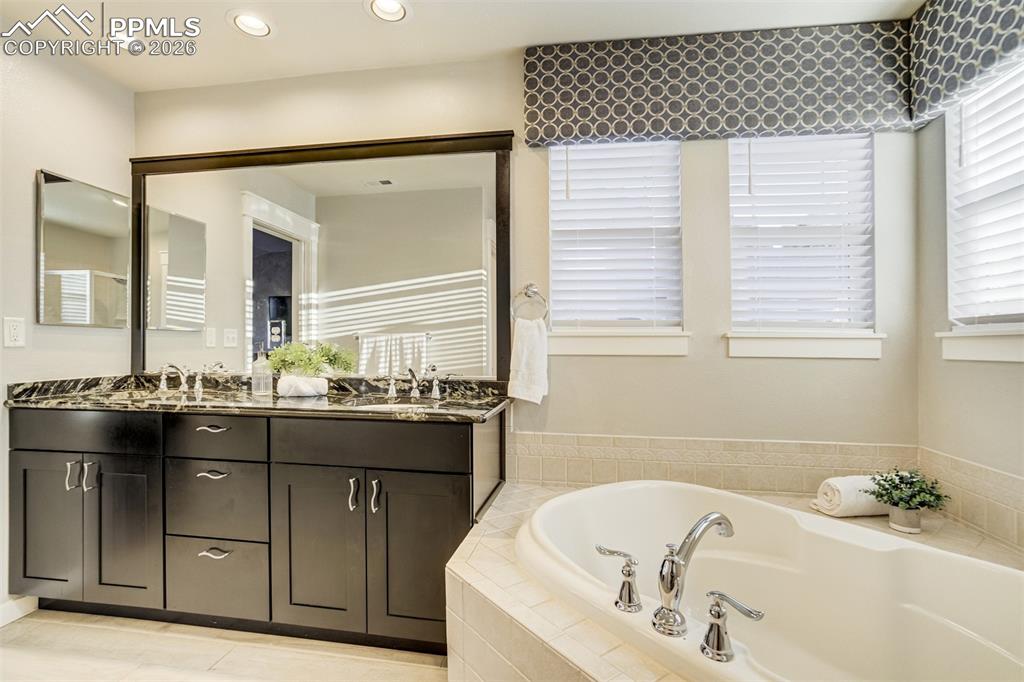Enjoy a double vanity with granite countertops