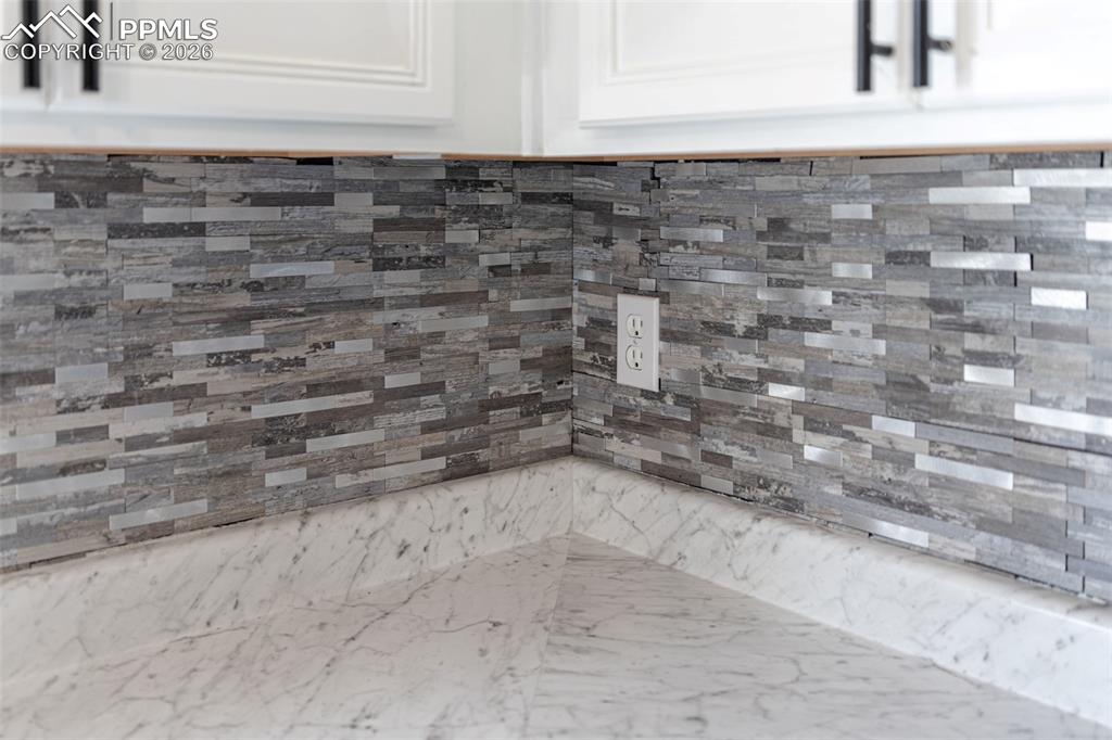 Kitchen view of white cabinetry and upscale backslash