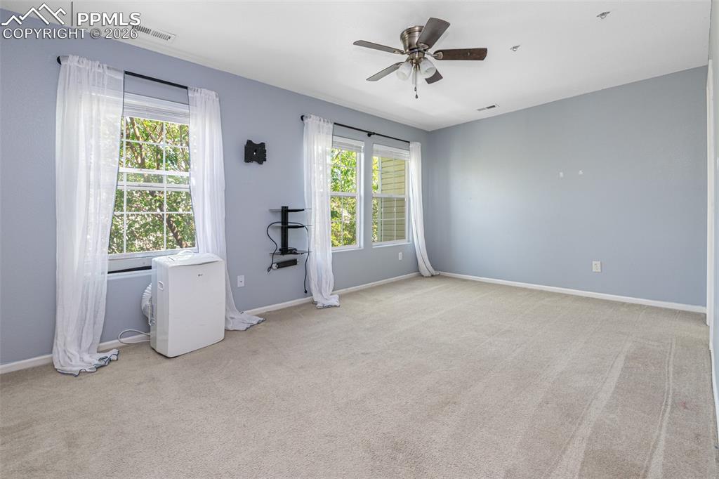 Unfurnished room with ceiling fan and light carpet