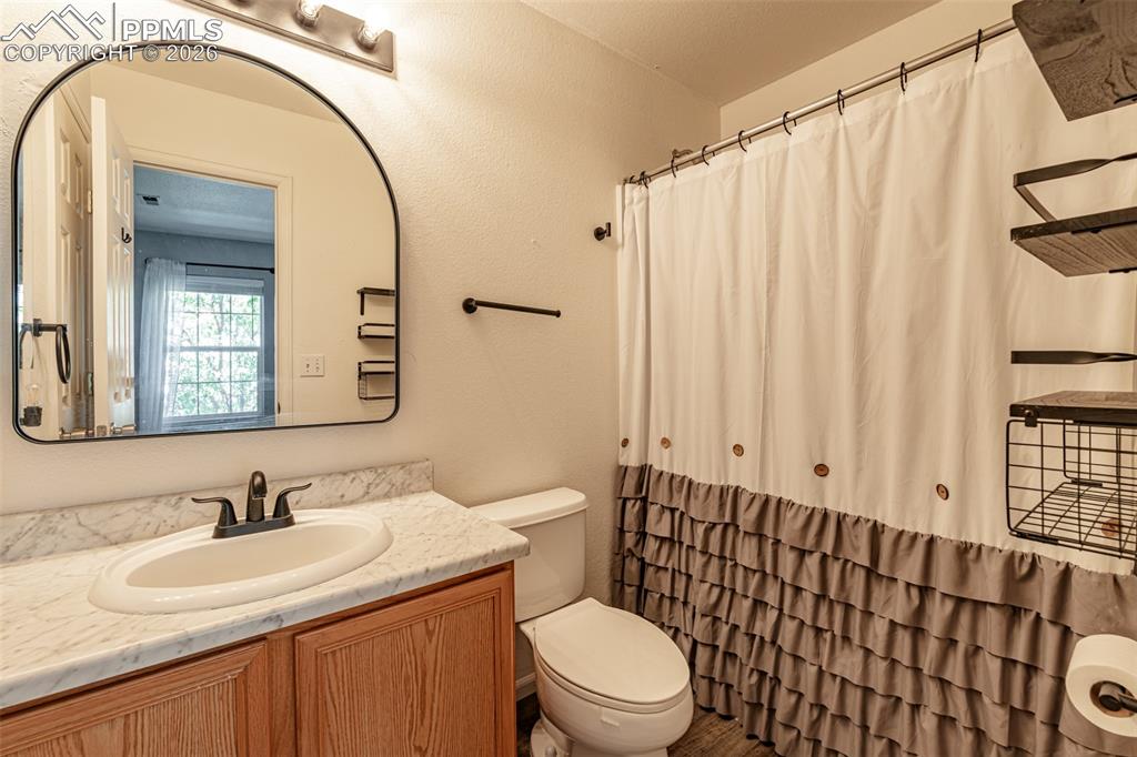 Bathroom featuring a shower with shower curtain and vanity