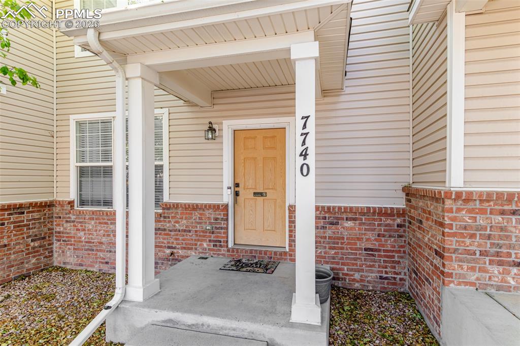 View of exterior entry featuring covered porch