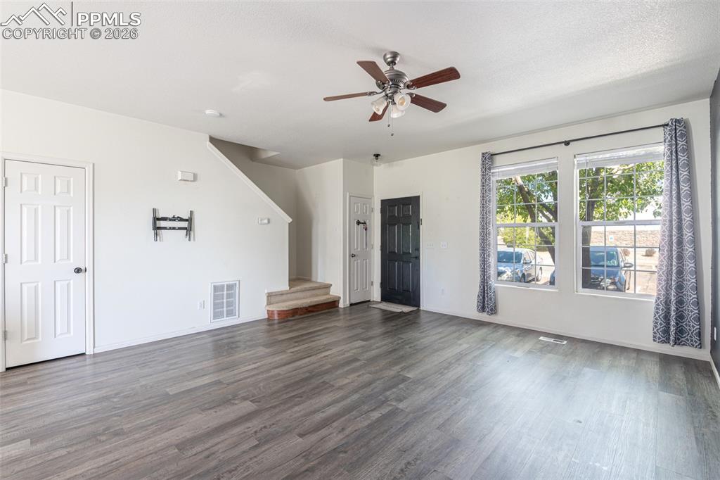 Unfurnished living room featuring ceiling fan and wood finished floors