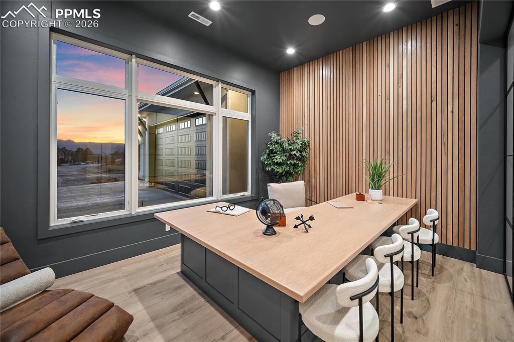 A study featuring a custom wood slatted accent wall that enhances the home’s sophisticated design.