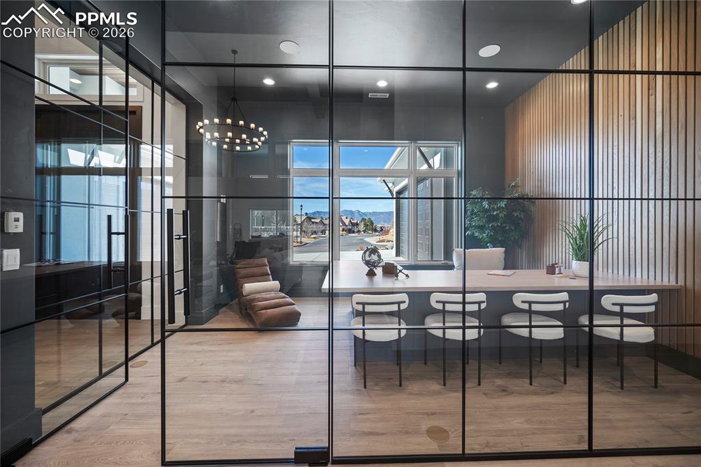 A stunning office/study with a built-in desk and mountain views, enclosed in glass to stay connected to the home while still providing a quiet, private workspace.