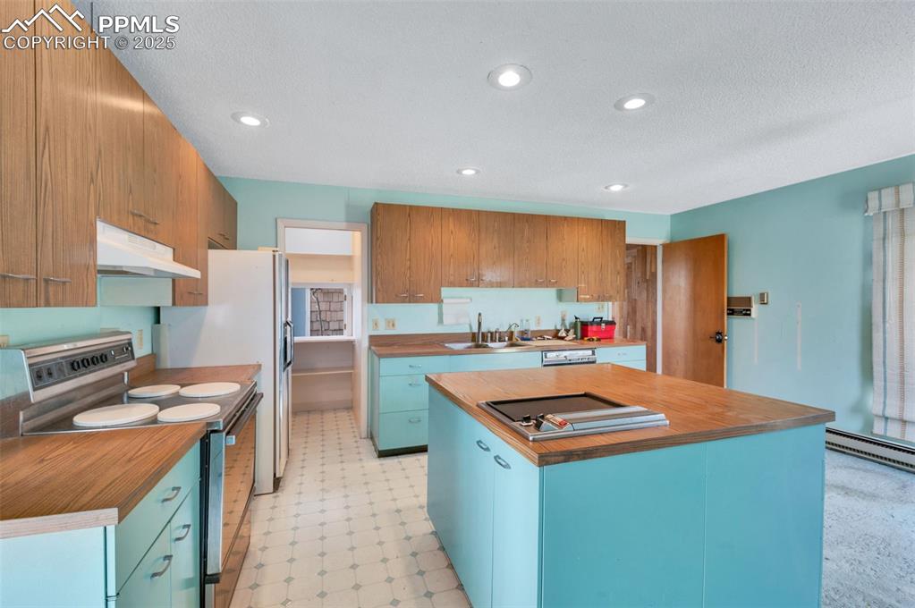 The kitchen is elevated with classic St. Charles cabinetry. the 4' square island has a jennair range and multiple cabinets 