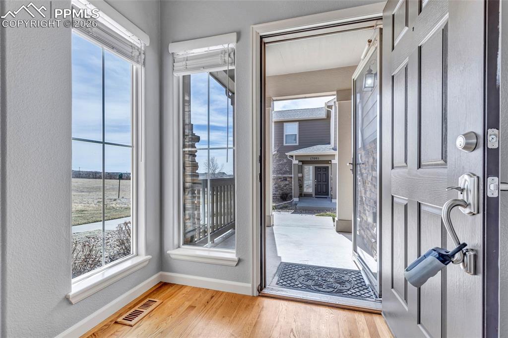Hardwood floors, floor to ceiling windows with new window coverings