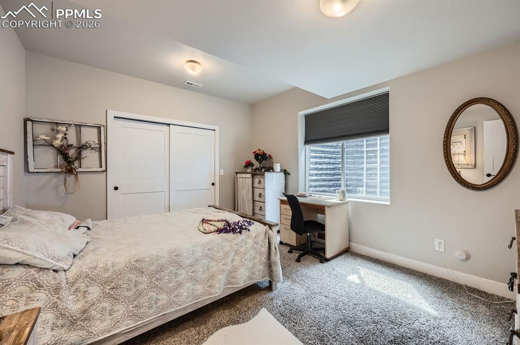 Bedroom featuring carpet flooring, baseboards, and a closet
