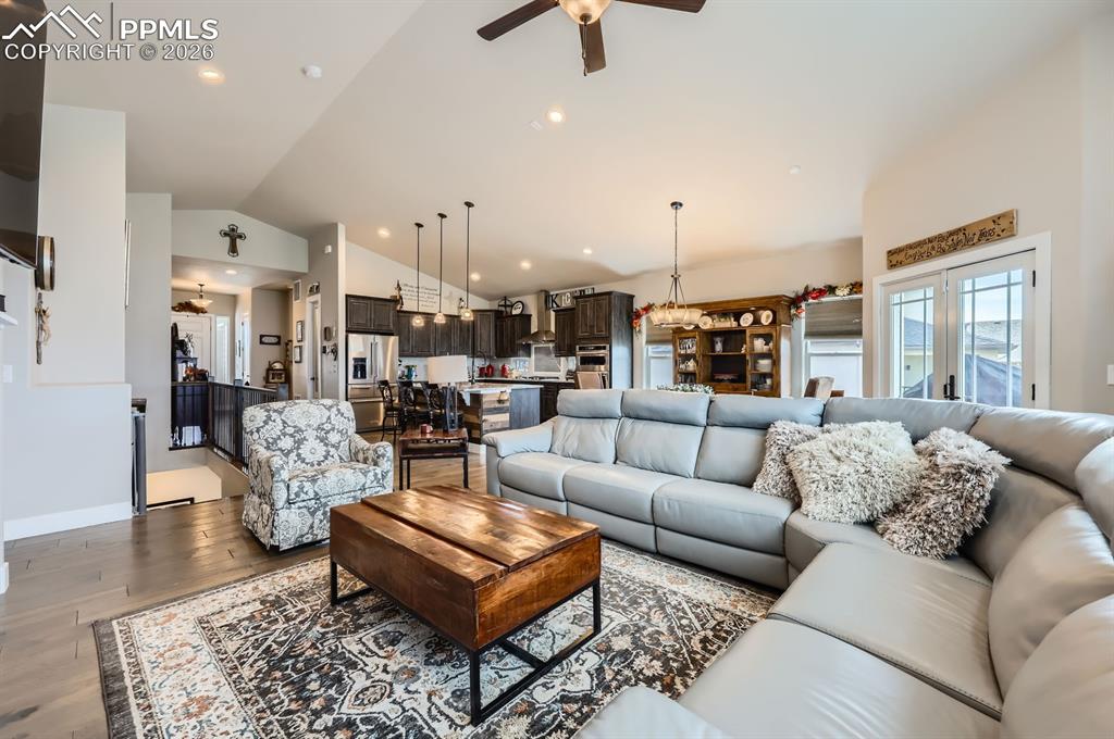 Living area featuring lofted ceiling, ceiling fan, wood finished floors, and recessed lighting