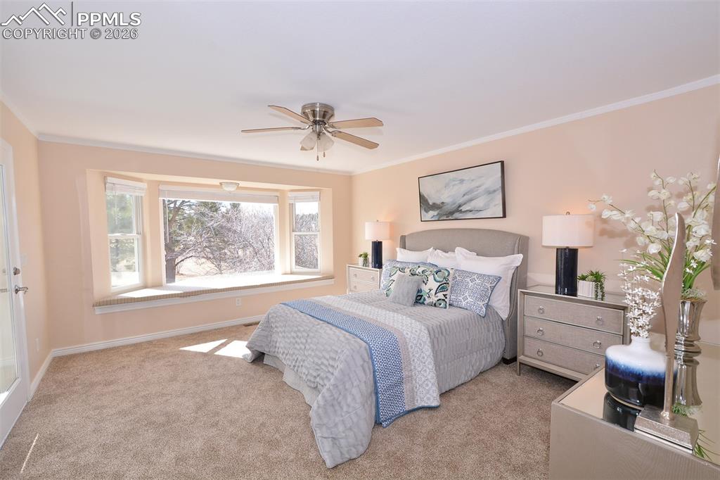 Lovely master bedroom with window seat and ceiling fan.