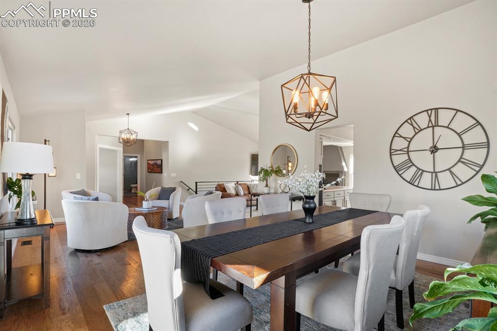 Dining room featuring lofted ceiling, an inviting chandelier, and dark hardwood / wood-style floors