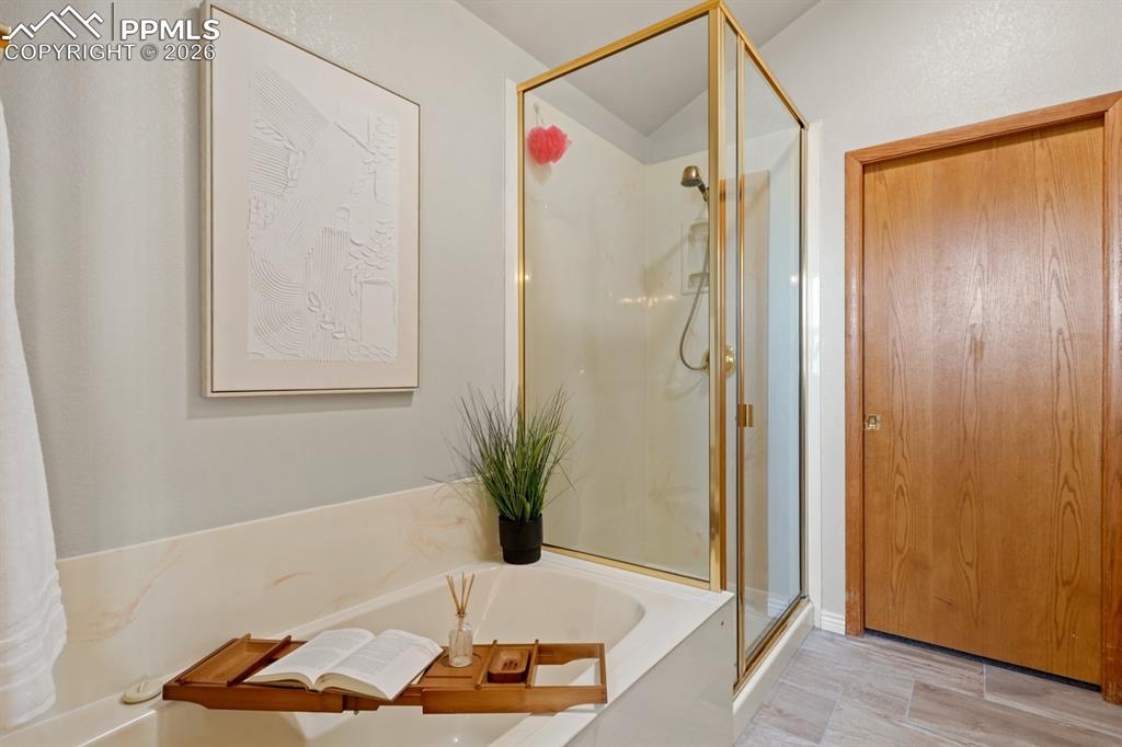 Bathroom featuring hardwood / wood-style flooring and plus walk in shower
