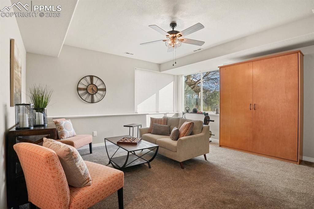 Carpeted living room with ceiling fan