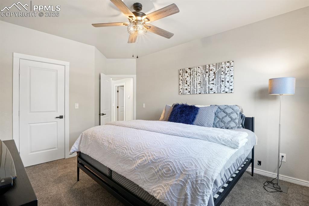 Bedroom featuring dark colored carpet and ceiling fan