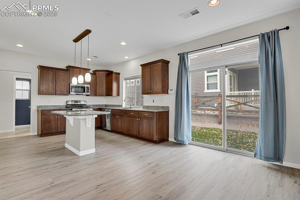 Kitchen featuring pendant lighting, dark brown cabinetry, light wood-style floors, and recessed lighting