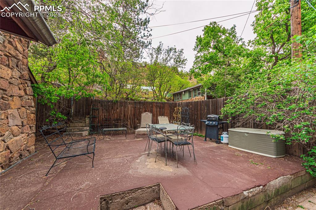 Fenced backyard with a patio area, a grill, and outdoor dining area