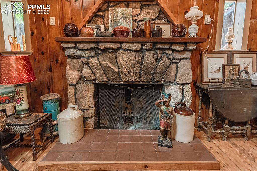 Detailed view of wood walls, a fireplace, and wood finished floors