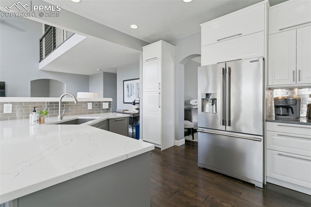 Large storage cabinets above the refrigerator and a view of one of the two extra-large pantry closets!