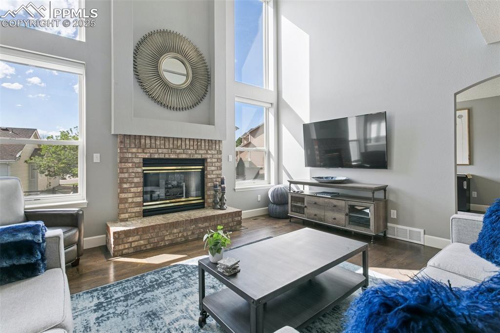 The cozy gas fireplace is framed by four large windows! Roller shades are remote-controlled and offer plenty of filtered light when closed!