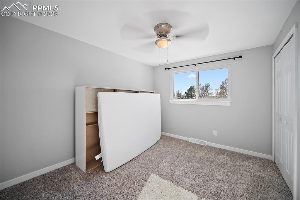 Unfurnished bedroom featuring a closet, carpet floors, and ceiling fan