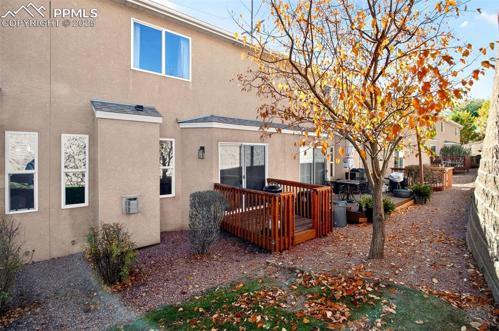Back of house featuring a wooden deck and stucco siding
