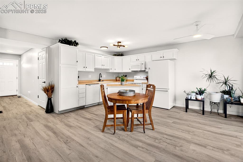 Dining space with light wood finished floors and ceiling fan