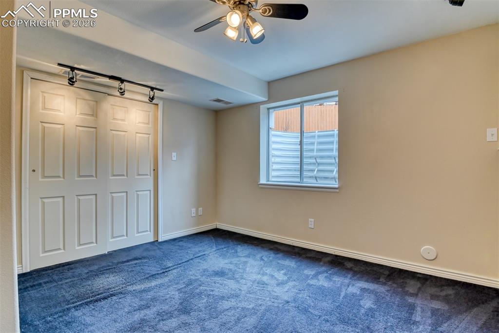 Basement bedroom has closet, fan, and egree window. 