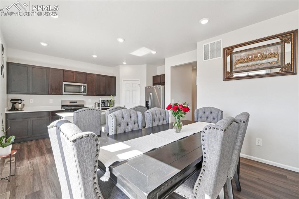 Dining room featuring dark wood-style floors and recessed lighting