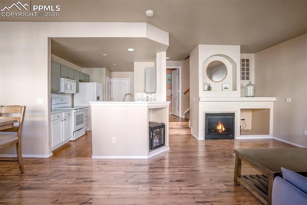 Kitchen and access to 1/2 bath and living room area with fireplace