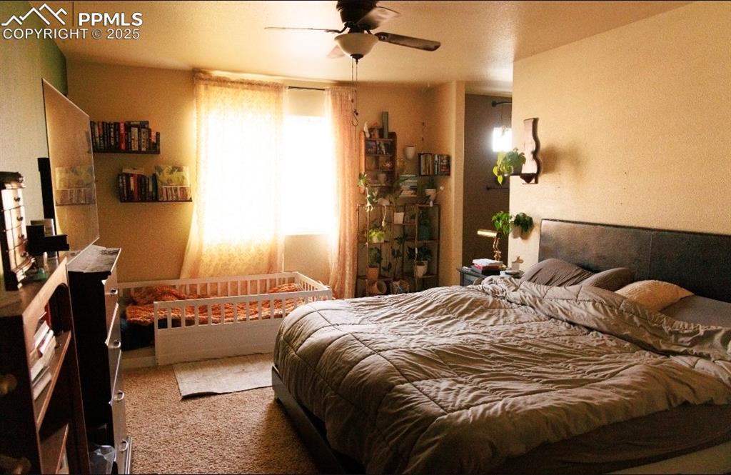 Carpeted bedroom featuring a ceiling fan