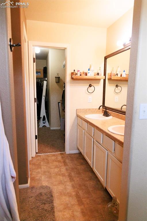 Full bath with double vanity and baseboards
