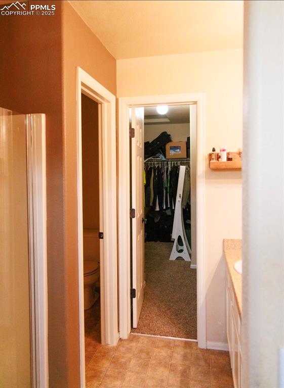 Hall with light colored carpet and light tile patterned flooring